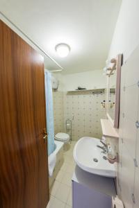 een badkamer met een wastafel, een toilet en een bad bij Bed & Breakfast Hotel California in Terracina