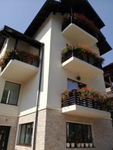 een wit gebouw met bloembakken op de balkons bij Casa Hera in Sinaia