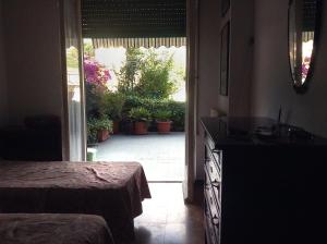 a bedroom with a door leading to a patio with plants at Condominio Marina in Rapallo