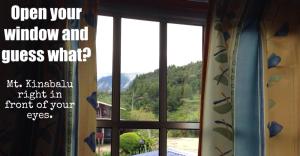 an open window with a view of a mountain at Kinabalu Valley Guesthouse in Kampong Kundassan