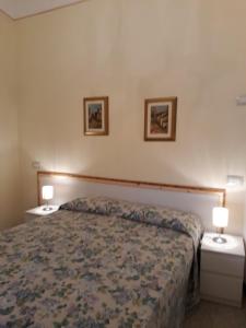 a bedroom with a bed with two night stands and two lamps at Grandpa Mau in Lucca