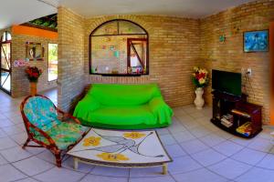 ein Wohnzimmer mit einer grünen Couch und einem Stuhl in der Unterkunft Hotel Pousada Porto do Colibri in Porto De Galinhas