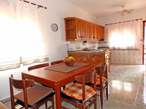 a kitchen with a wooden table and chairs in a room at Apartamentos Medano - Casa Playa in El Médano