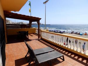 d'un balcon avec une chaise et une vue sur la plage. dans l'établissement Apartamentos Medano - Casa Playa, à El Médano