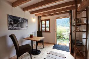 Zimmer mit einem Tisch, Stühlen und einem Fenster in der Unterkunft La Foyère in Aime La Plagne
