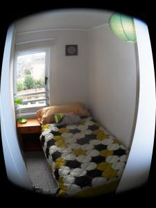 um quarto com uma cama, uma secretária e uma janela em Departamento en Ñuñoa em Santiago