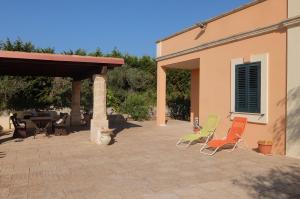 - un ensemble de chaises assises sur une terrasse dans l'établissement Villa Serracca, à Gagliano del Capo