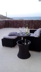 un patio con una mesa con copas de vino. en Roca Mar Tenerife, en La Mareta