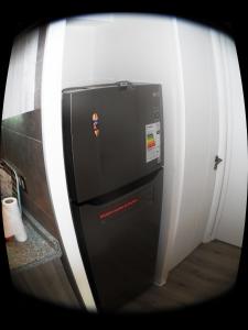 um frigorífico preto com um autocolante na lateral em Departamento en Ñuñoa em Santiago