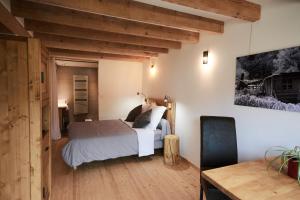 um quarto com uma cama branca e piso em madeira em La Foyère em Aime La Plagne