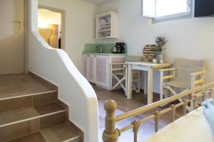 a staircase leading to a kitchen with a table and chairs at Portes Houses in Koufonisia