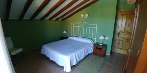 a bedroom with a white bed and green walls at Apartamentos Antonio in Ubiarco