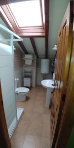 a bathroom with a toilet and a sink and a window at Apartamentos Antonio in Ubiarco