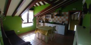 a kitchen with green walls and a table with chairs at Apartamentos Antonio in Ubiarco +17 photos