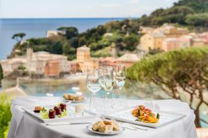a table with plates of food and wine glasses at Hotel Vis à Vis in Sestri Levante