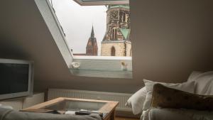 una sala de estar con vistas a una torre del reloj. en Private Apartment & Hannover City Altstadt, en Hannover