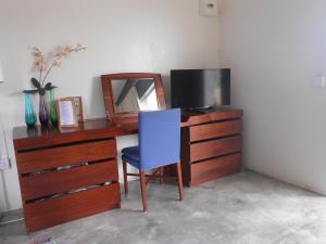 Rodrigues Island的住宿－阿弗爾公寓，一张带镜子和蓝椅的桌子