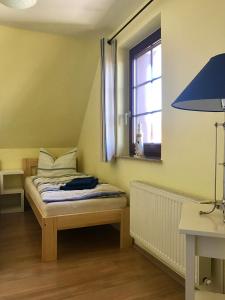 a small bedroom with a bed and a window at Landhaus Selma in Wieck
