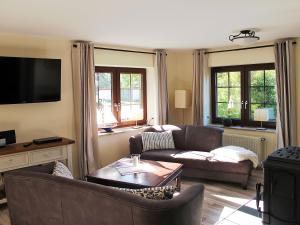 a living room with two couches and a tv at Landhaus Selma in Wieck +5 photos