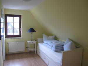a small bedroom with a bed with a window at Landhaus Selma in Wieck