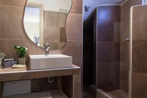 a bathroom with a sink and a mirror at Portes Houses in Koufonisia