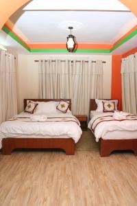 two beds in a room with orange and green walls at Thamel Backpackers Home in Kathmandu