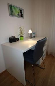 a white desk with a lamp and a chair at Kurzzeit-Apartment Nussdorf in Vienna