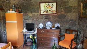 a room with a wooden dresser with a computer on it at Casa de piedra a 2 km de la Playa in La Aldea de San Nicolas