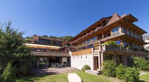 a large wooden building with tables and chairs at Auberge La Meuniere in Thannenkirch