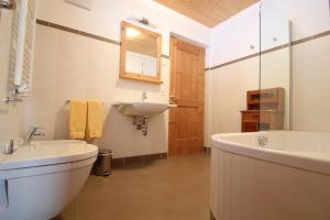 a bathroom with a sink and a toilet and a tub at Mitterhof in Ultimo +41 photos
