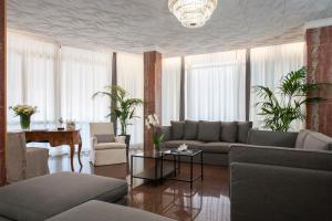 uma sala de estar com um sofá e uma mesa em Hotel Imperial Palace em Lido di Jesolo