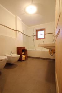 a bathroom with a toilet and a sink and a tub at Mitterhof in Ultimo