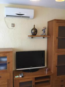 een flatscreen-tv op een houten entertainmentcentrum bij Apartamento Sonia in Torremolinos