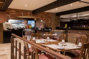un ristorante con tavolo, sedie e un bar di Krystal Urban Aeropuerto Ciudad de Mexico a Città del Messico