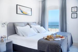 a hotel room with a bed with a tray of food on it at Hotel Mar Bravo in Nazaré