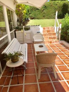 un patio con banco, mesa y sillas en Estudio a 10 minutos del Puerto Banus en Estepona
