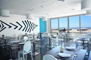 a restaurant with tables and chairs and a view of the beach at Hotel Mar Bravo in Nazaré