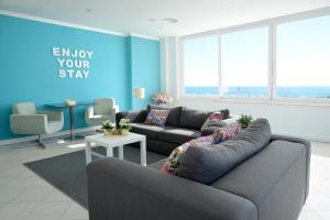 a living room with a couch and a blue wall at Hotel Mar Bravo in Nazaré