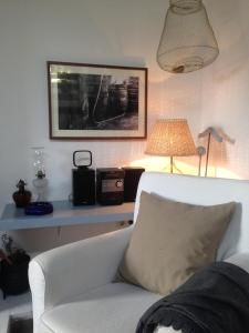 een woonkamer met een witte bank en een lamp bij CasadaVinhaGrande in Biscoitos