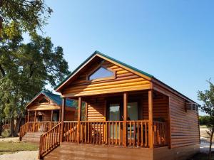 Cabaña de madera con porche y terraza en Al's Hideaway Cabin and RV Space, LLC en Pipe Creek