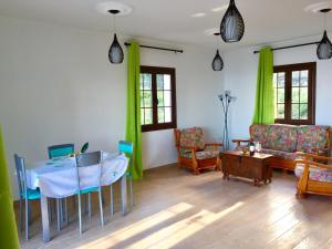 a living room with a table and green curtains at Costa Este House in Monte de Breña