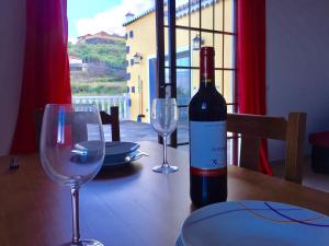 a bottle of wine sitting on a table with two glasses at Costa Este House in Monte de Breña