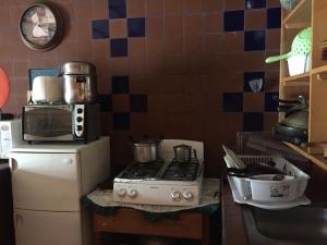 a kitchen with a stove and a microwave at Hostal Sueños Del Río in Boquete