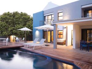 a house with a wooden deck and a swimming pool at 7 Ackermann Place Guest House in Stellenbosch