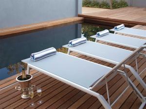 two picnic tables on a deck with wine glasses at 7 Ackermann Place Guest House in Stellenbosch