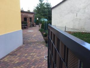a fence with a brick walkway next to a building at Kleine Herberge in Strodehne