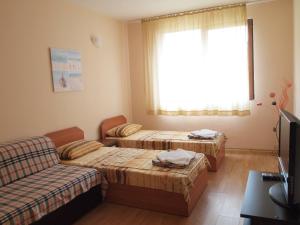 プリモルスコにあるApartments in complex Gardeniaのベッド2台とソファが備わる客室です。