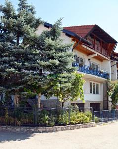 una casa con un árbol delante de ella en "Athos"apartment potkrovlje, en Višegrad