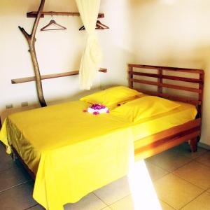 ein Schlafzimmer mit einem gelben Bett mit Blumen darauf in der Unterkunft Corales Punta Rusia in Punta Rucia
