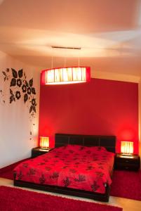 a red bedroom with a bed and two lamps at Tsentralniy Hotel in Khmelʼnytsʼkyy